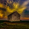 An old wooden barn under a dramatic sunset sky